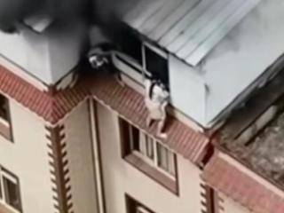 昆明一栋楼着火，一家四口抱着孩子站在窗檐边呼救