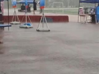 防城港一所中学冒雨举办活动，工作人员大雨中致辞