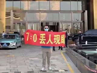 “7-0丢人现眼”！球迷手持刺眼横幅，亮相国足酒店！球员未在场